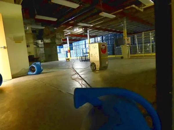 Air movers and a dehumidifier drying a large commercial space in Huntington Station, NY