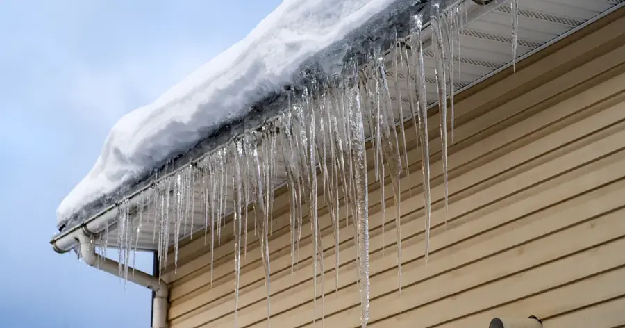 Icicles hanging from a snow-covered roof edge in Huntington Station, NY
